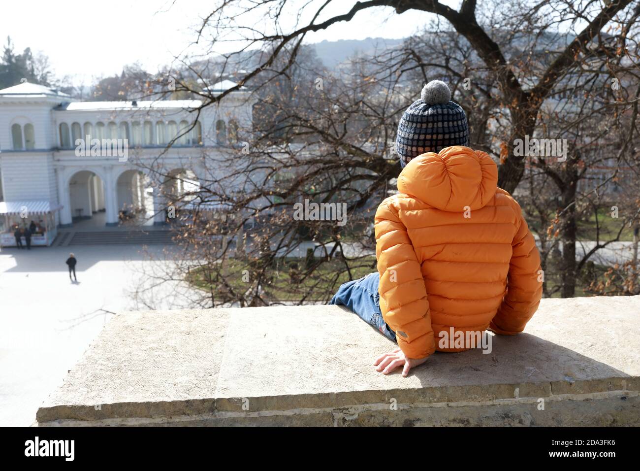 Bambino seduto sulla parete del sito di Lermontov, Kislovodsk, Russia Foto Stock