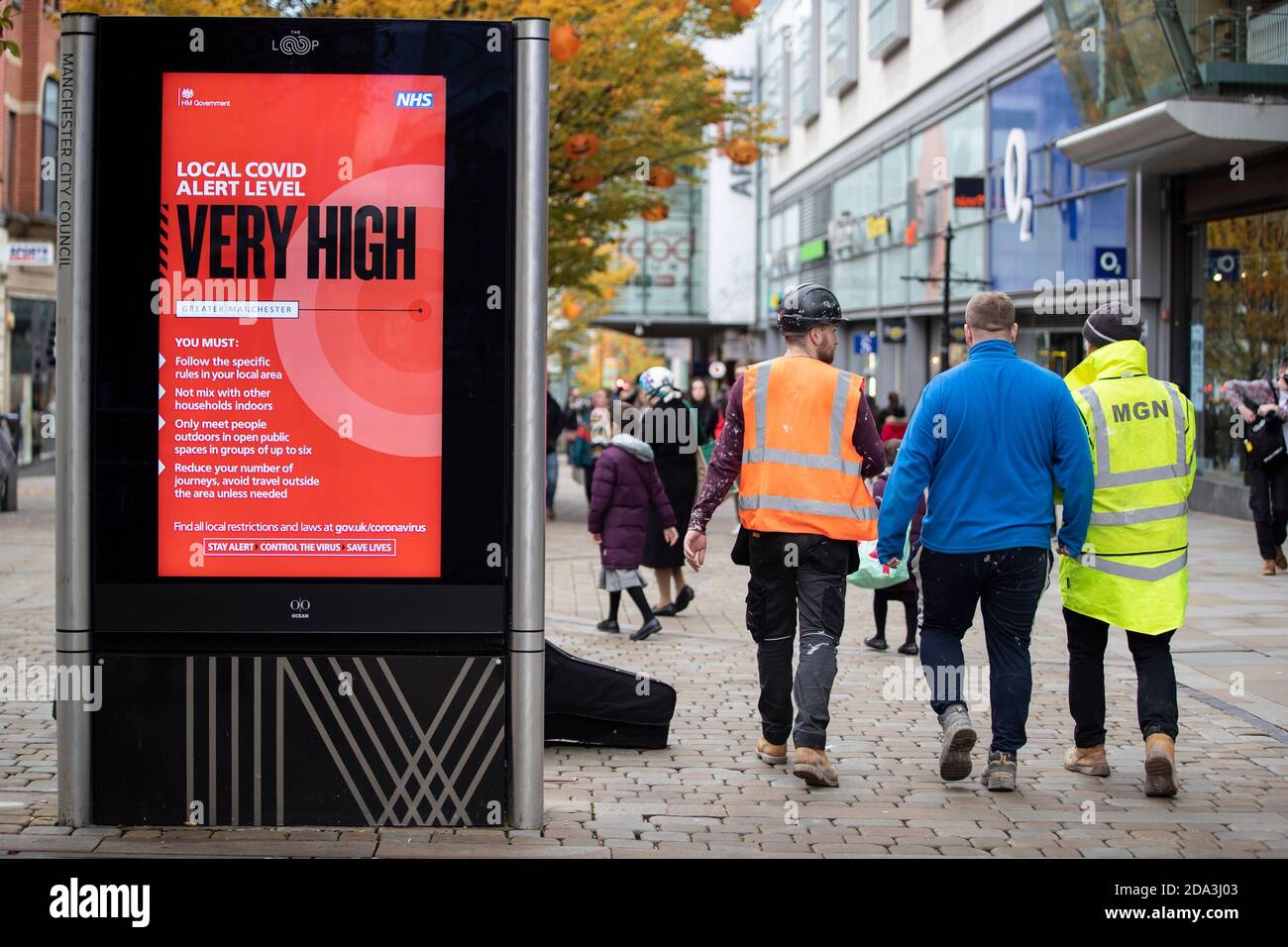 © concesso in licenza a London News Pictures. 25/10/2020. Manchester, Regno Unito. I lavoratori camminano oltre un covid molto alto livello di allarme segno su Market Street, Manchester. Sho Foto Stock