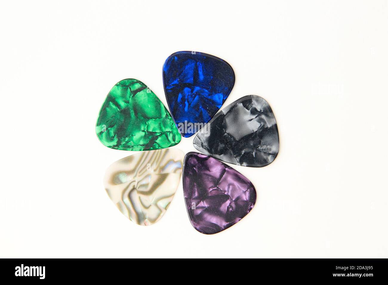 Coloratissime scelte di chitarra disposte in un motivo floreale su un sfondo bianco Foto Stock
