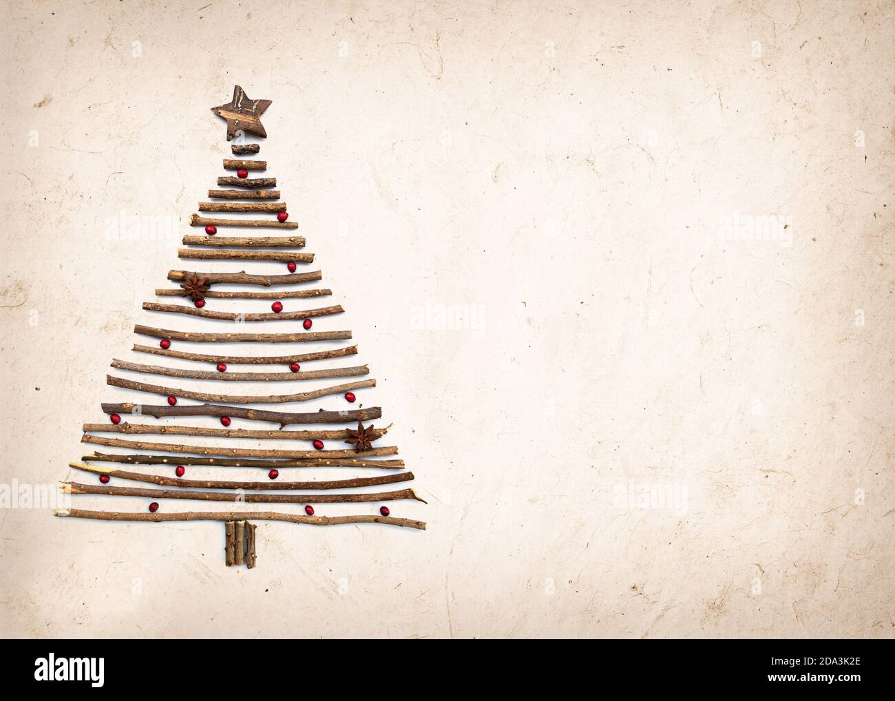 Albero di Natale rustico e creativo fatto a mano con rami di legno su carta backgound con spazio per la copia Foto Stock