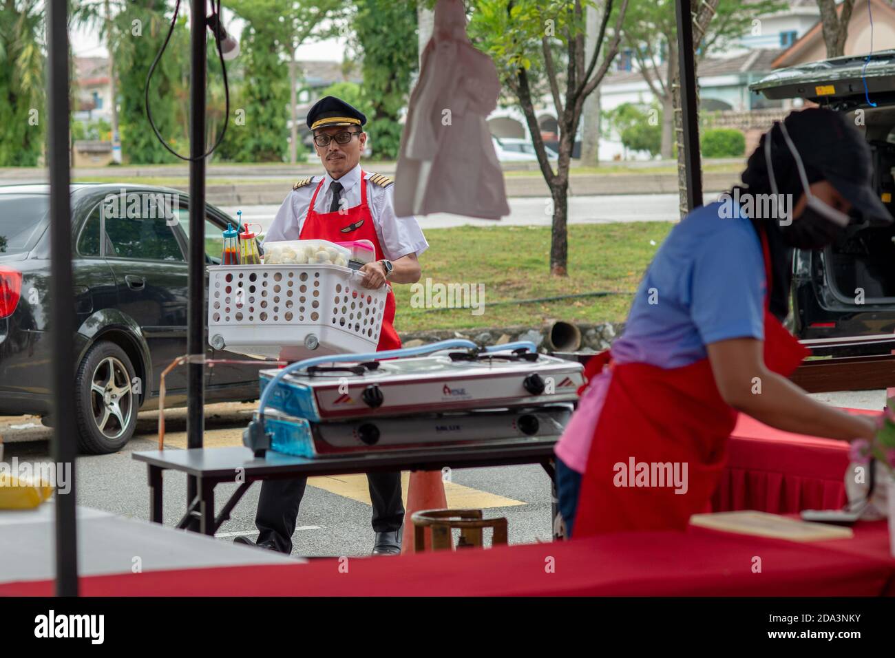 Subang Jaya, Malesia. 9 Nov 2020. Azrin Mohamad Zawawawi in uniforme pilota trasporta gli ingredienti alla sua stalla in Subang Jaya vicino a Kuala Lumpur, Malesia, 9 novembre 2020. PER ANDARE CON 'Feature: Pilota malese 'vola' avanti con il proprio business dopo aver perso lavoro in mezzo COVID-19' Credit: Chong Voon Chung/Xinhua/Alamy Live News Foto Stock