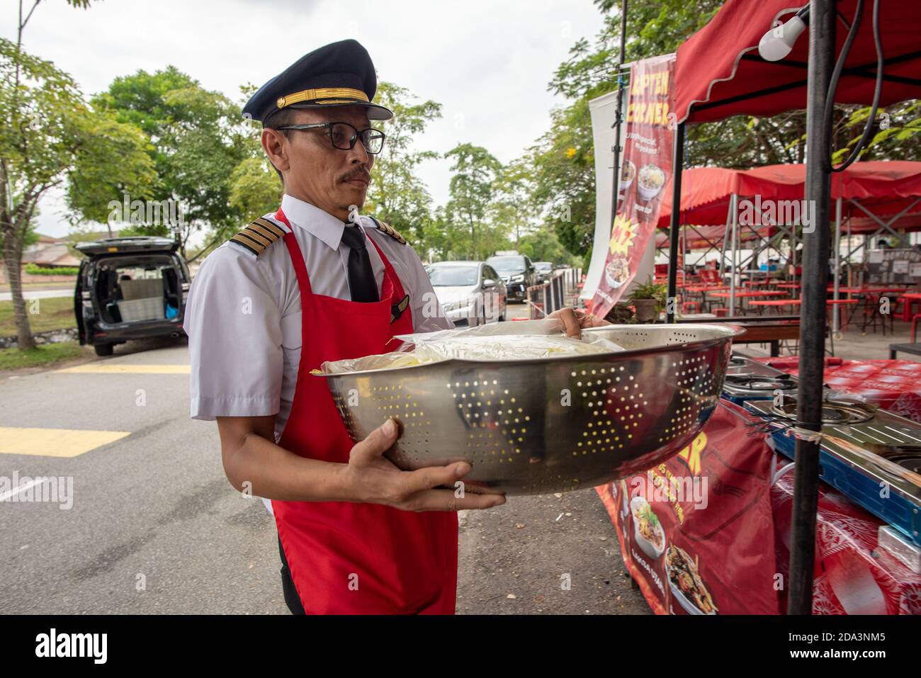 Subang Jaya, Malesia. 9 Nov 2020. Azrin Mohamad Zawawawi in uniforme pilota trasporta gli ingredienti alla sua stalla in Subang Jaya vicino a Kuala Lumpur, Malesia, 9 novembre 2020. PER ANDARE CON 'Feature: Pilota malese 'vola' avanti con il proprio business dopo aver perso lavoro in mezzo COVID-19' Credit: Chong Voon Chung/Xinhua/Alamy Live News Foto Stock