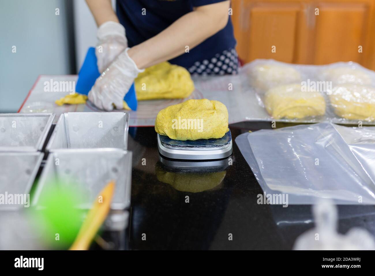 Donna che pesa pasta di pane di zucca fatta in casa su una scala. Foto Stock