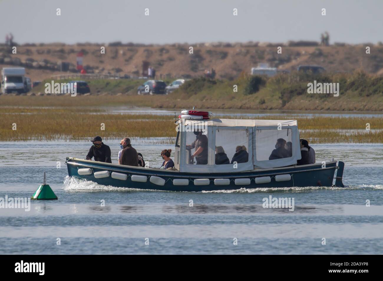 Piccolo traghetto da Keyhaven Marina al Castello di Hurst con passeggeri che indossano maschere, Keyhaven UK Foto Stock