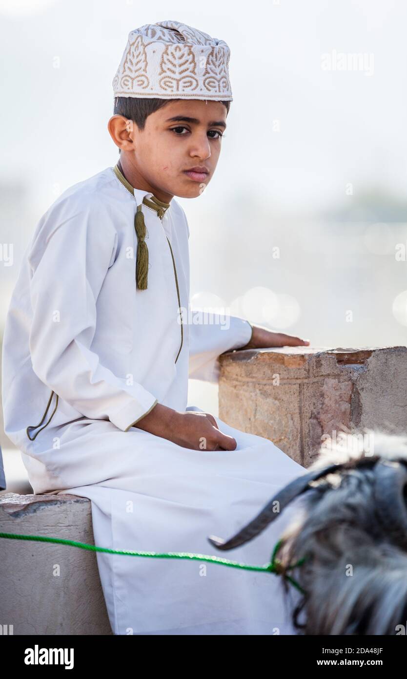 Nizwa, Oman, 2 dicembre 2016: Ritratto di un ragazzo locale in abiti tradizionali al mercato della capra del venerdì a Nizwa, Oman Foto Stock