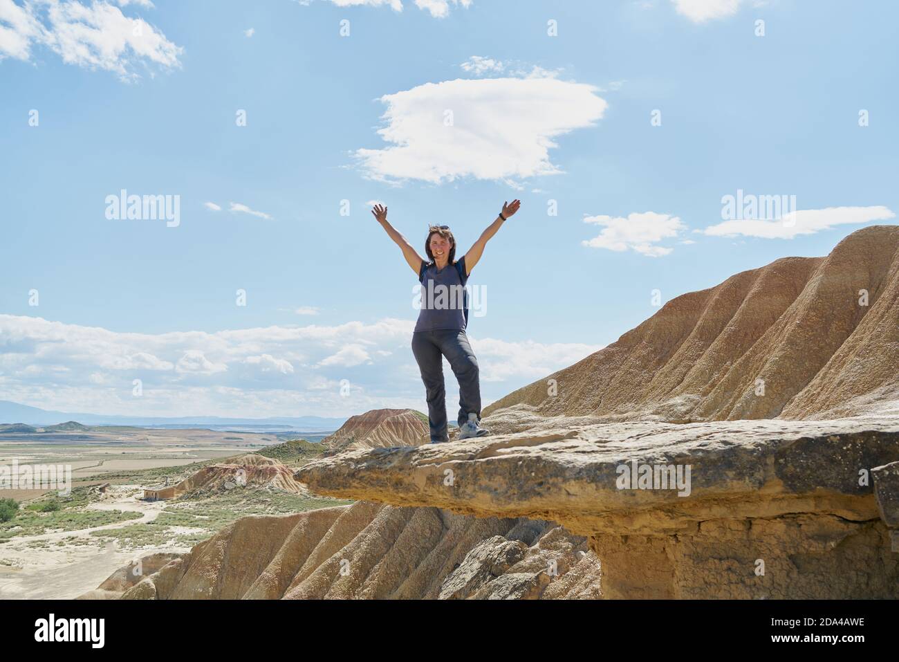 Una donna alza le braccia nel deserto di Bardenas Reales In Spagna Foto Stock