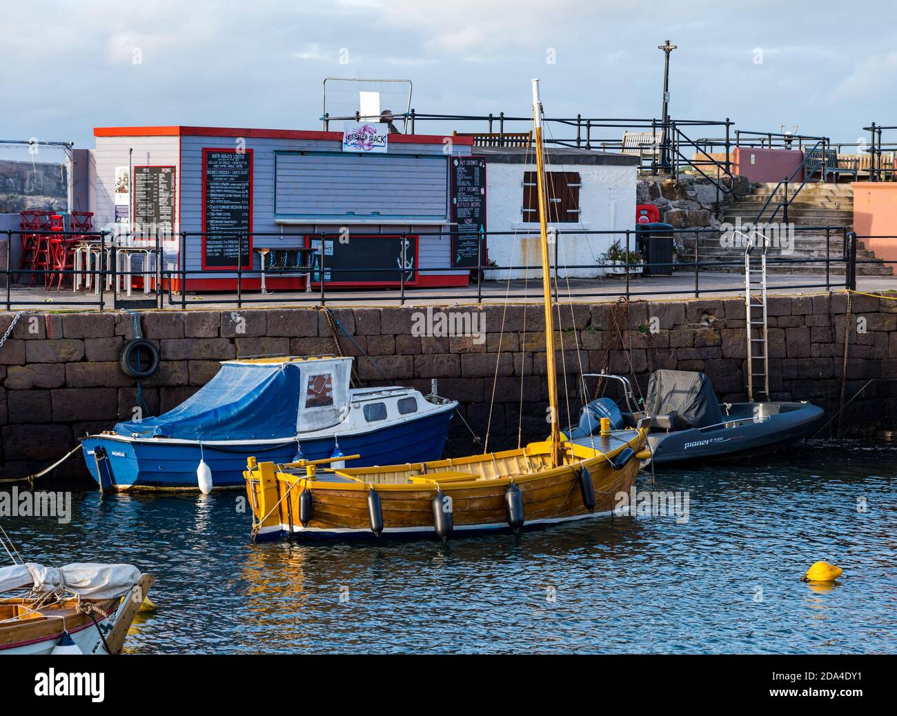 Piccole barche ormeggiate nel porto di Berwick Nord con Lobster Shack chiuso di pesce outlet, East Lothian, Scozia, Regno Unito Foto Stock