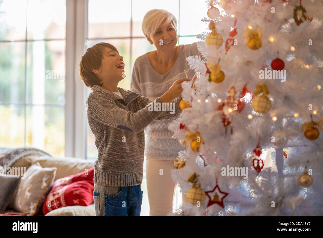 Madre e figlio decorare albero di Natale Foto Stock