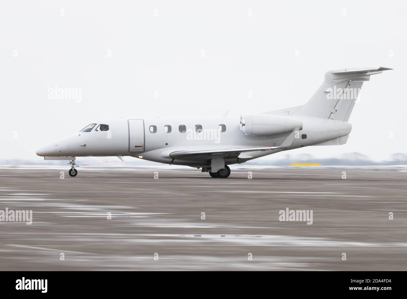 Vista laterale della piccola impresa privata Jet Tassing sulla pista per il decollo, in movimento, in inverno. Business, concetto di aviazione privata Foto Stock