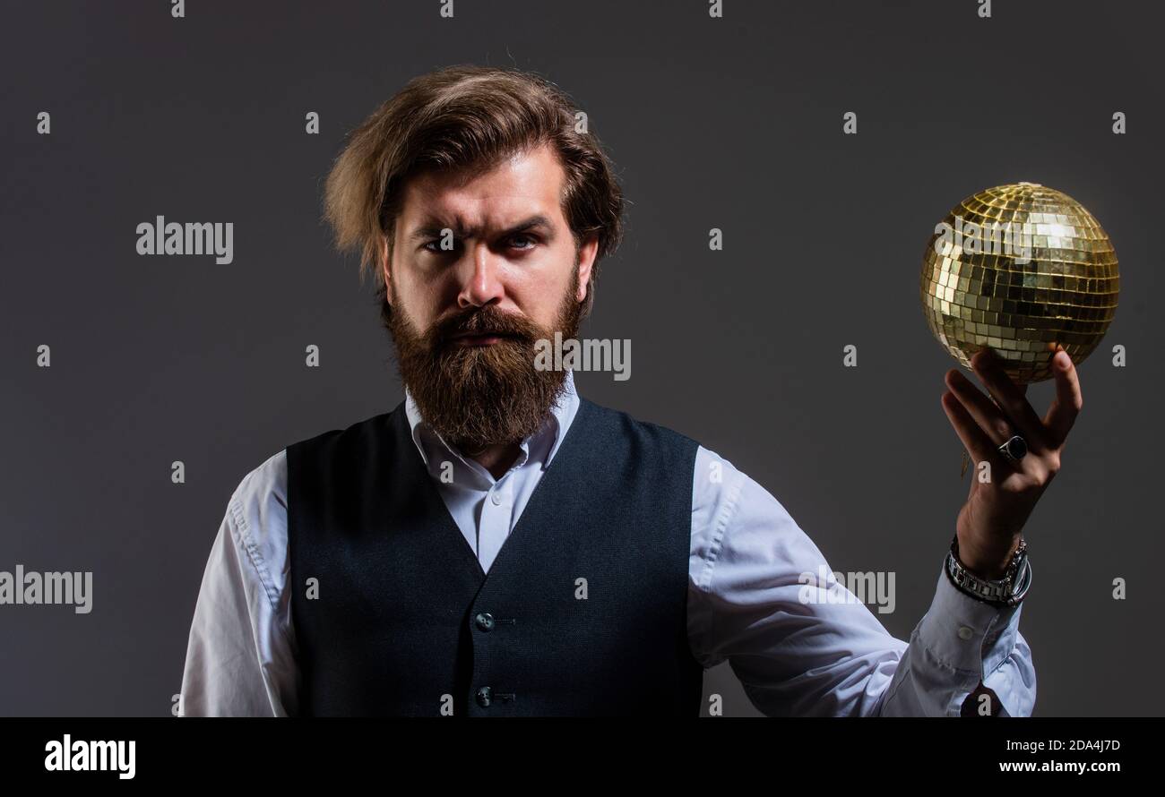 L'uomo maturo bearded tiene la sfera dorata della discoteca, concetto del randello dell'elite. Foto Stock