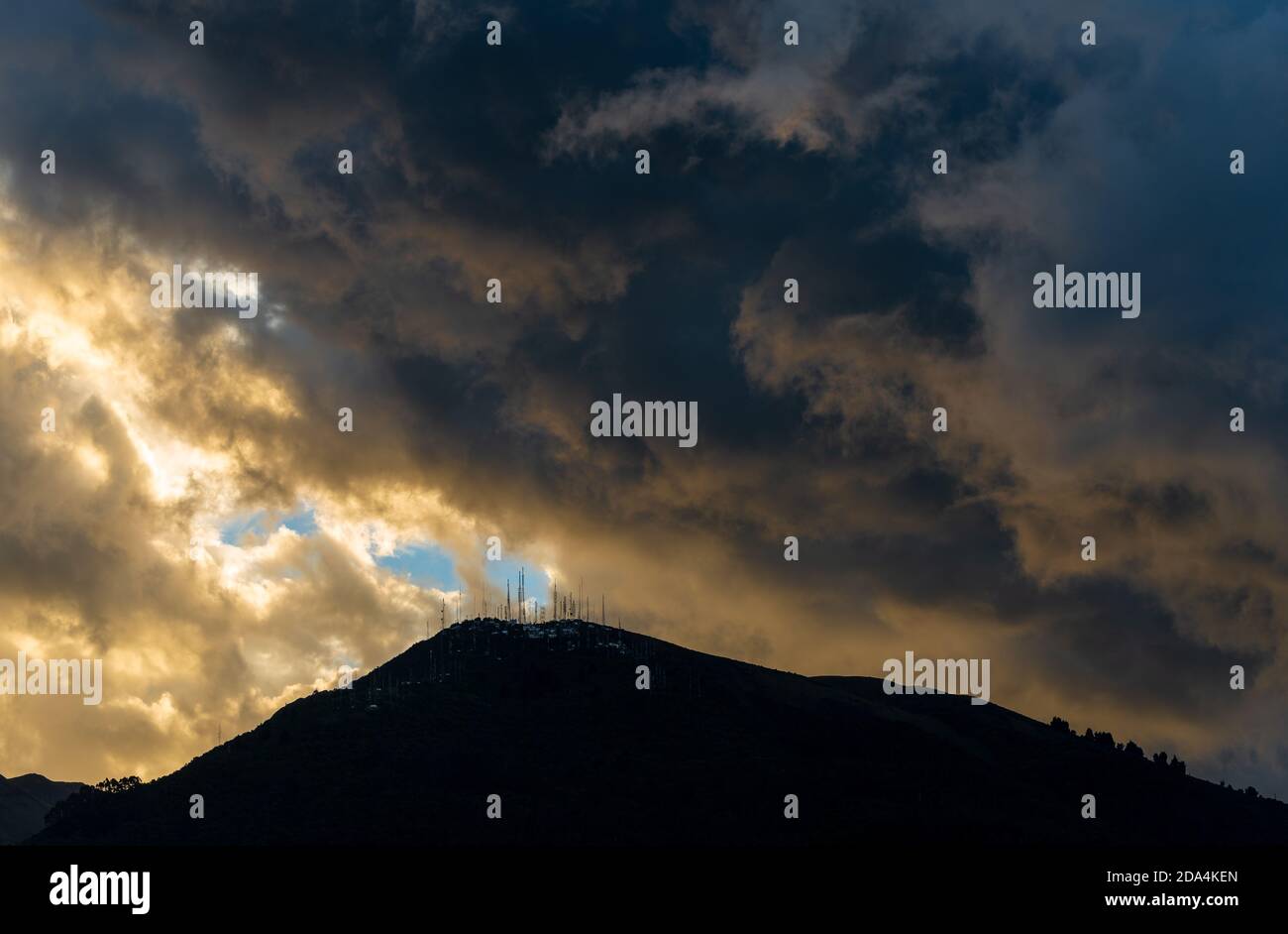 Drammatiche nuvole di pioggia sopra il vulcano Pichincha al tramonto con l'arrivo della stagione delle piogge a Quito, Andes montagne, Ecuador. Foto Stock