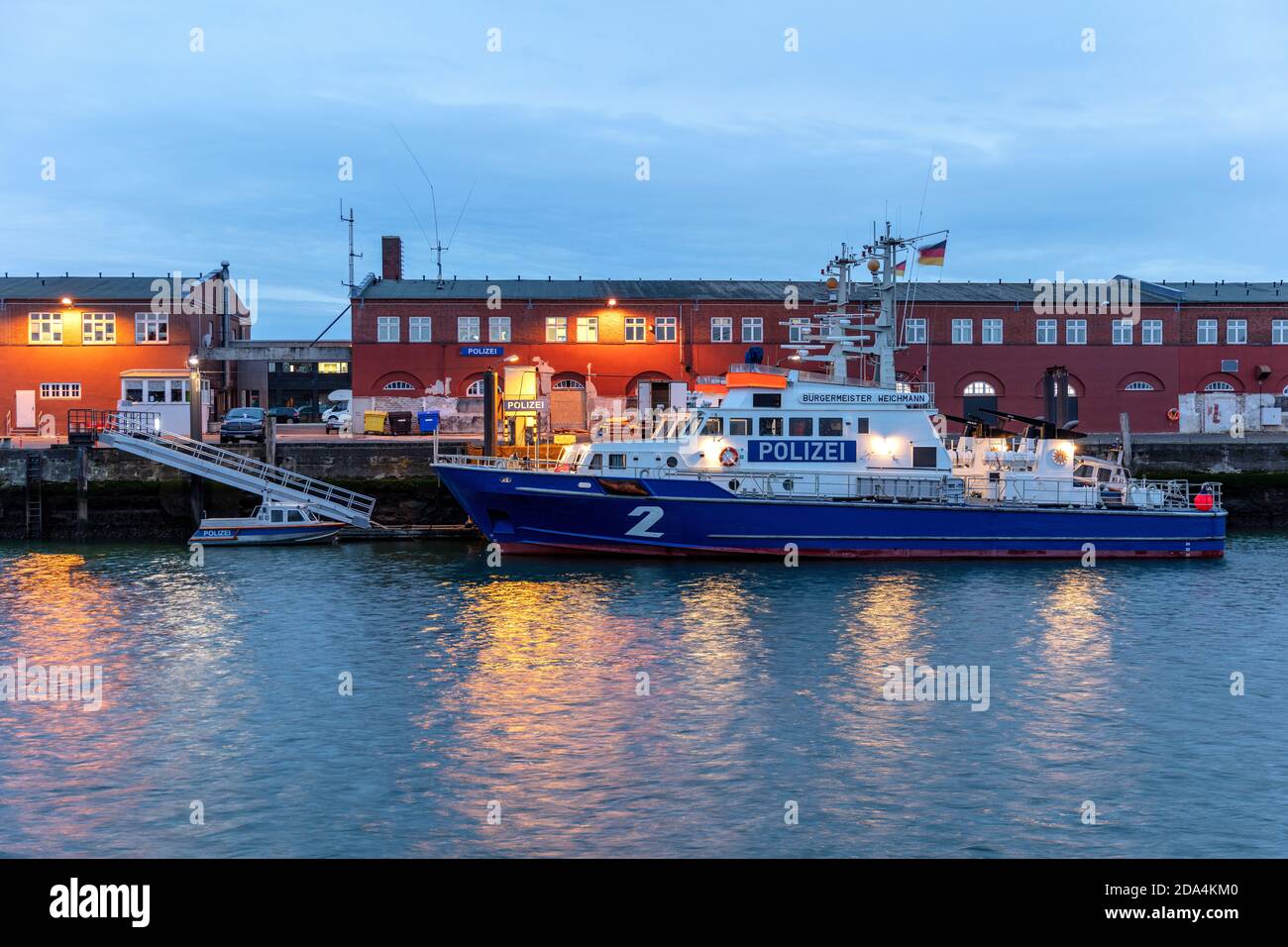 La polizia costiera di Amburgo pattuglia le barche nel porto di Cuxhaven, in Germania, durante la notte Foto Stock