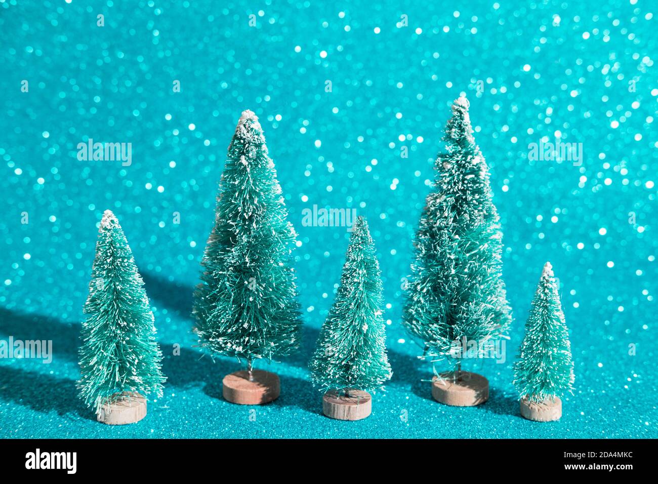 Natale sfondo festivo con alberi giocattolo di natale. Abstract glitter sfondo sfocato blu lucido ai aqua. Carta da parati brillante e brillante con bokeh t Foto Stock
