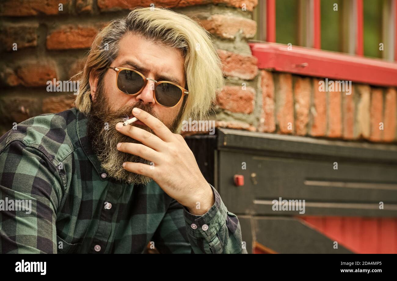 Hipster fumo vecchia architettura sfondo. Cannabis medica. Brutale ragazzo  occhiali da sole fumo tabacco. Fumare all'aperto. Abitudine di fumare. Uomo  maturo alla moda con sigaretta. Ragazzo fresco rilassante Foto stock - Alamy