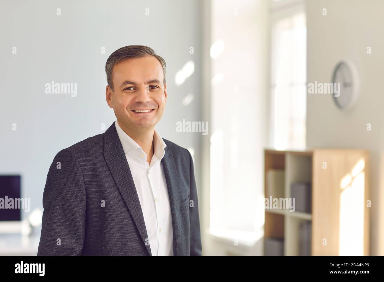 Ritratto di un uomo d'affari sorridente di mezza età in un costume da lavoro in ufficio. Foto Stock
