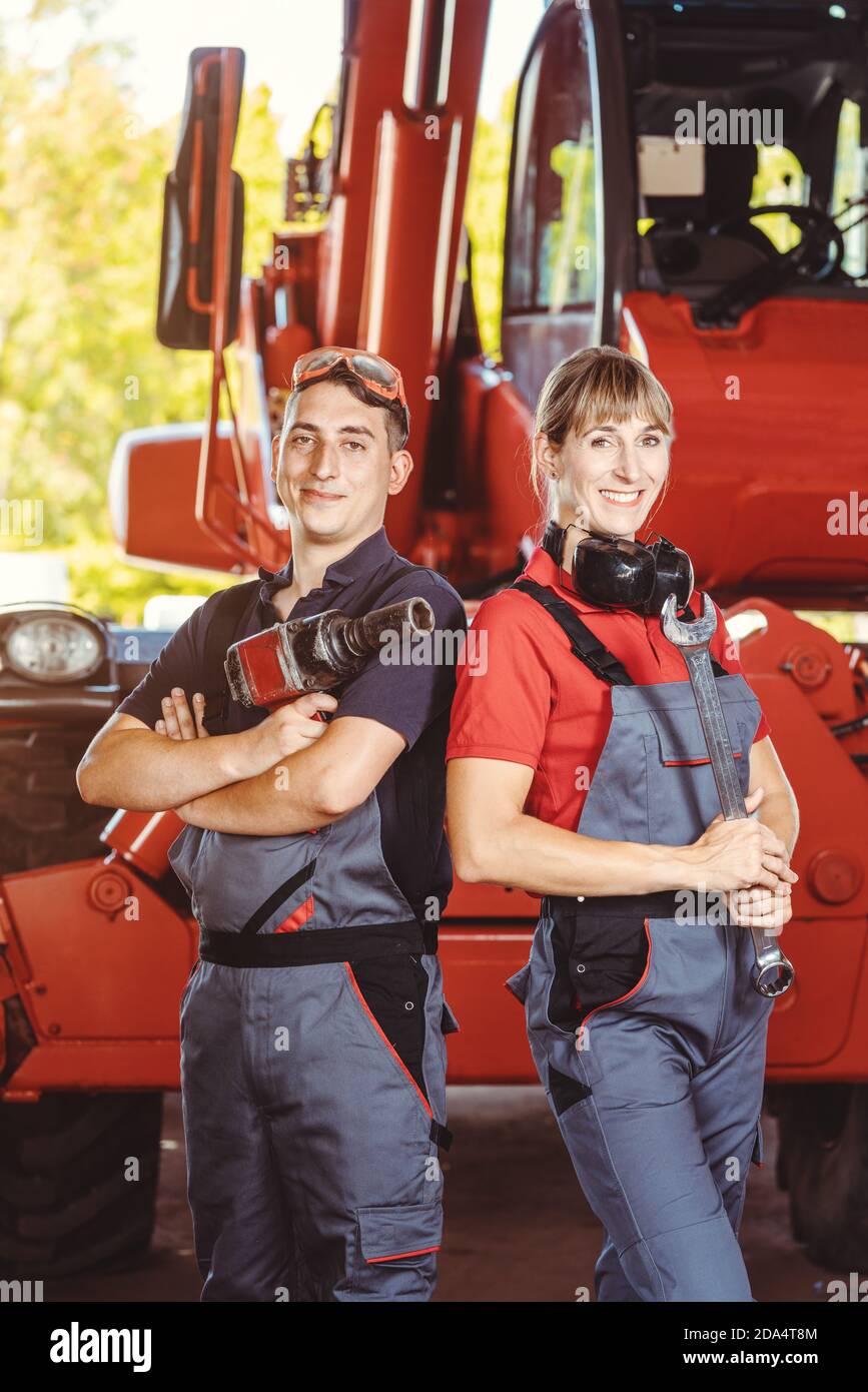 Due macchinisti per macchine agricole nel loro garage Foto Stock
