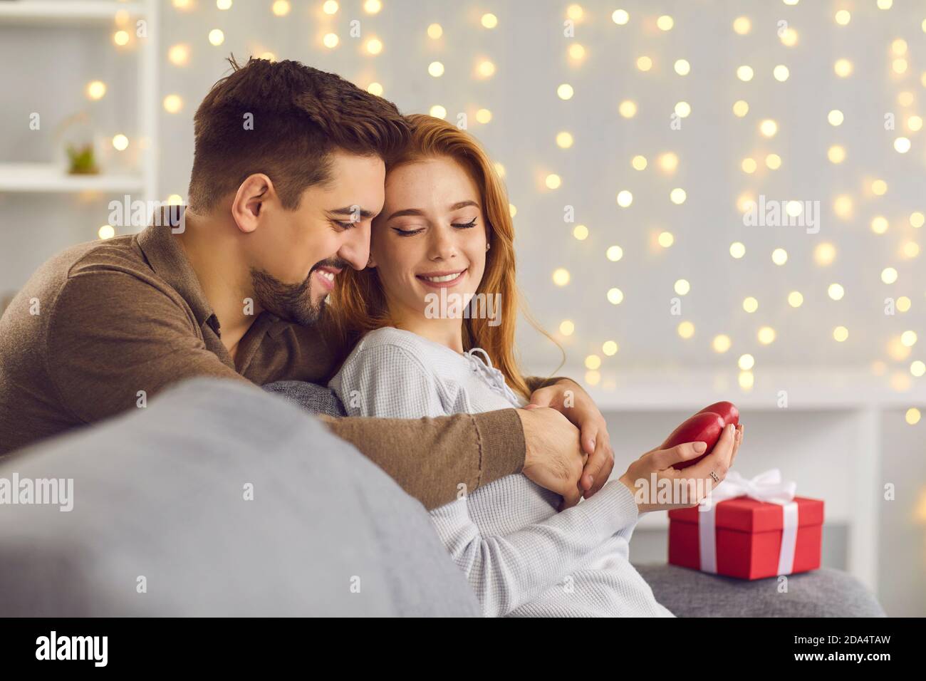 Felice giovane coppia che celebra San Valentino a casa e. godendo del tempo insieme Foto Stock