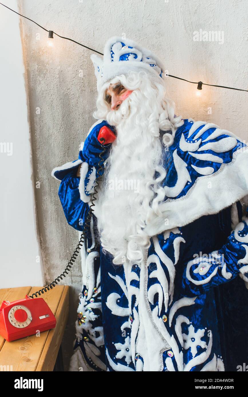 babbo natale al telefono a casa sua compila la wishlist per natale. Foto Stock