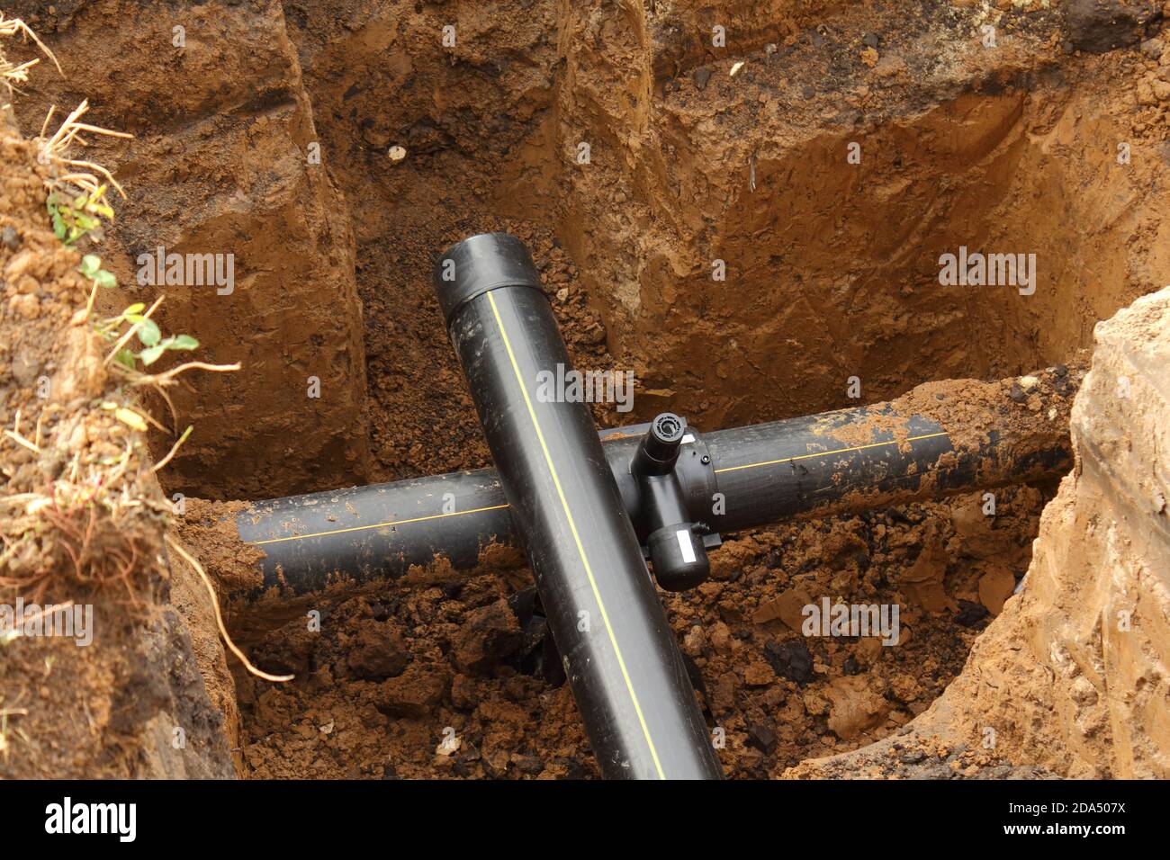 Estensione della conduttura sotterranea dell'acqua di PVC nella buca di argilla Foto Stock