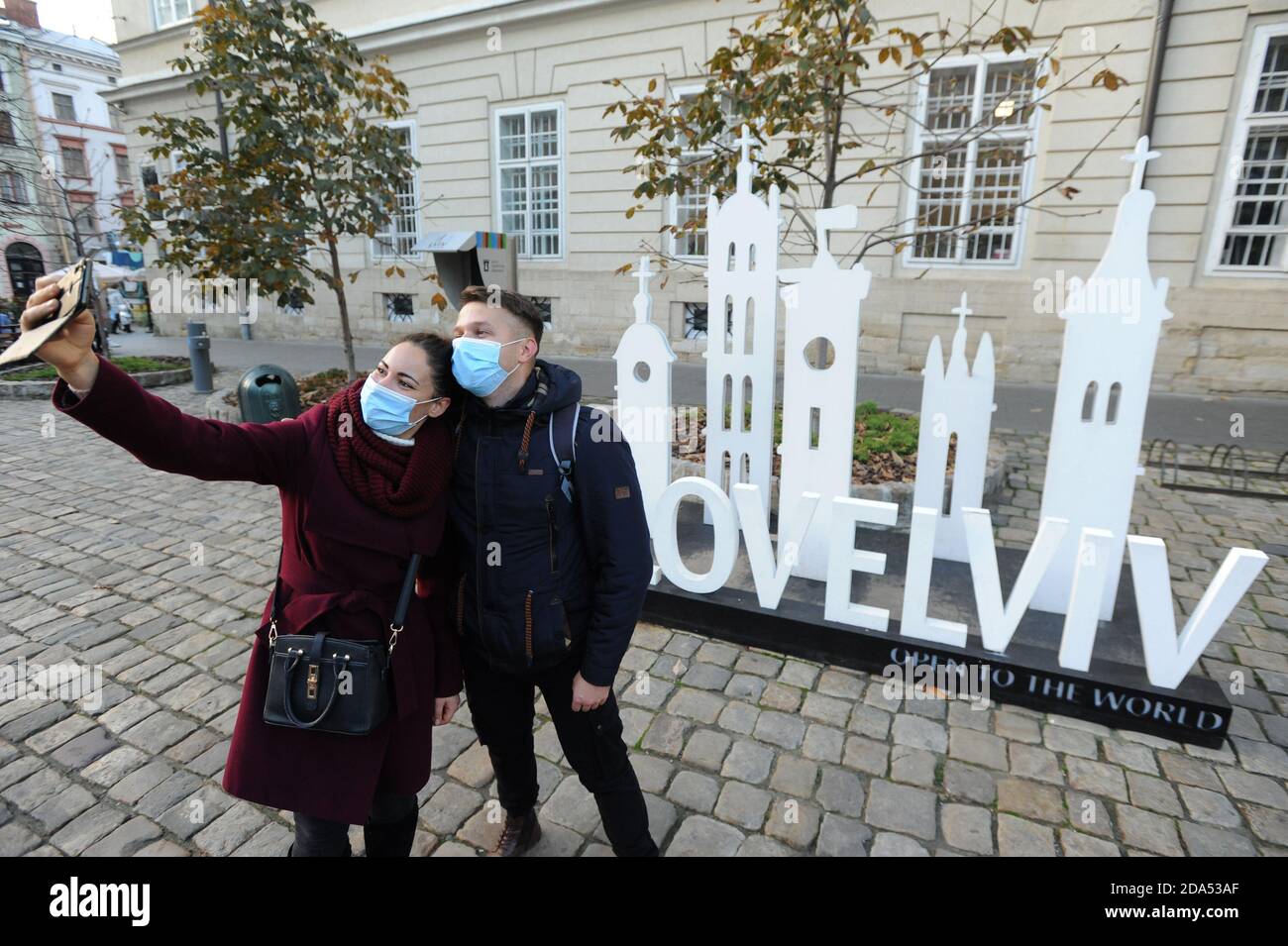 Lviv, Ucraina, 4 novembre 2020. La gente fa selfie in fronte del logo 'Love Lviv' che indossa il facemask nero come misura preventiva del coronavirus nel centro della città. Foto Stock