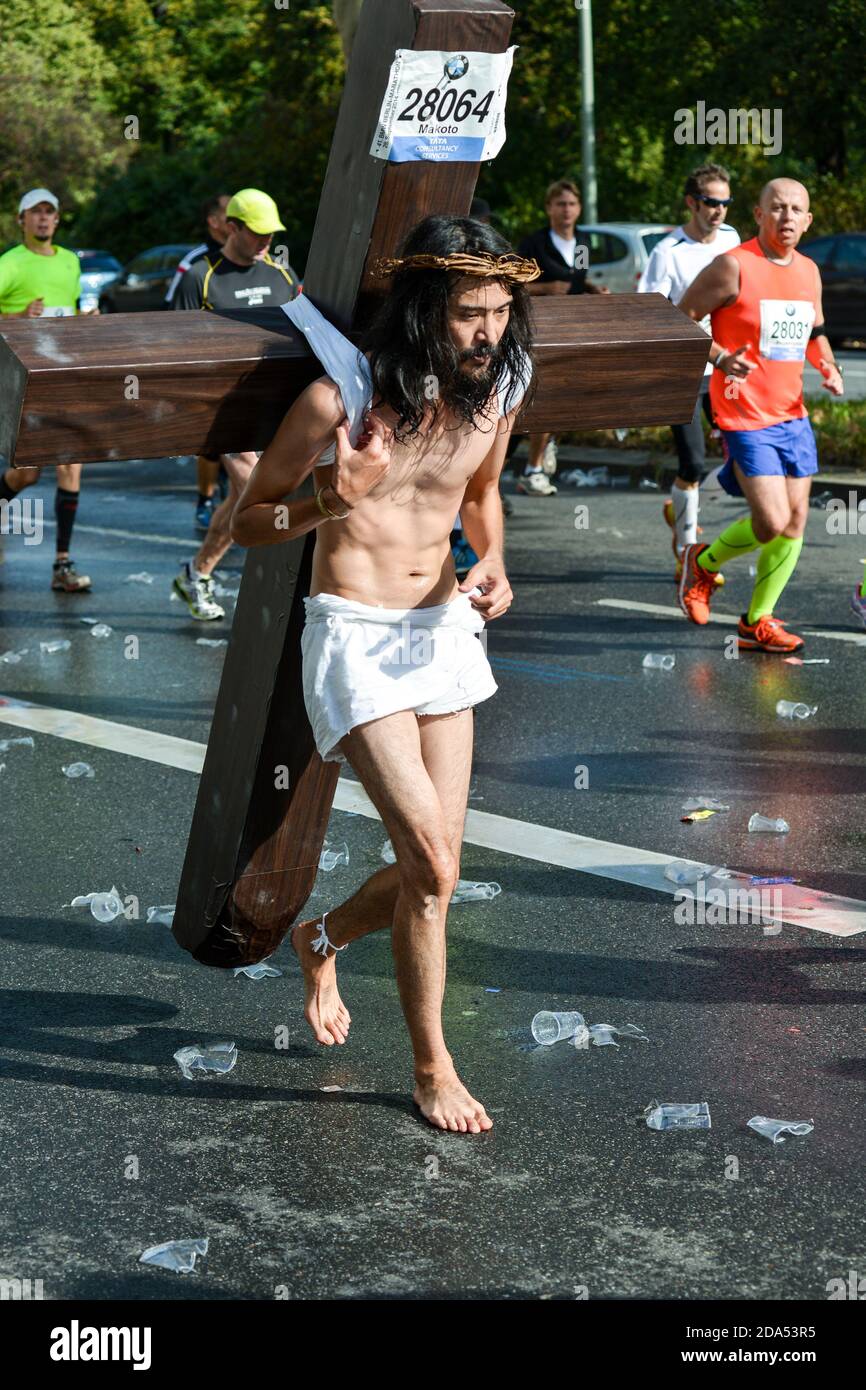 Jesus corre: Un corridore giapponese alla maratona di Berlino 2014 fasi una dimostrazione per la pace del mondo che porta una croce tutto il senso. Foto Stock