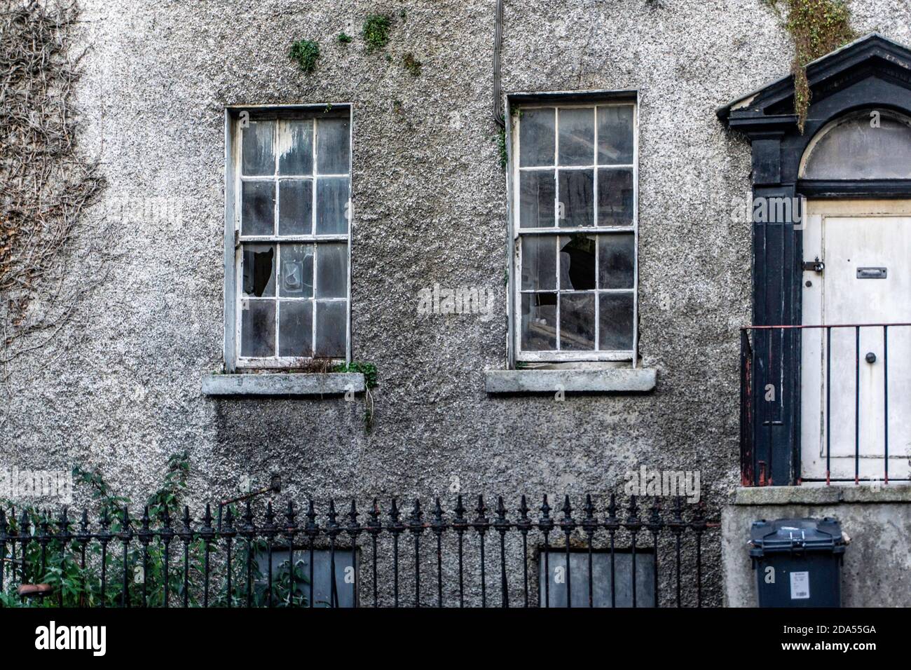 Chapelizod, primo piano di una casa abbandonata, che mostra le sue finestre rotte, a Chapelizod, Dublino, Irlanda Foto Stock