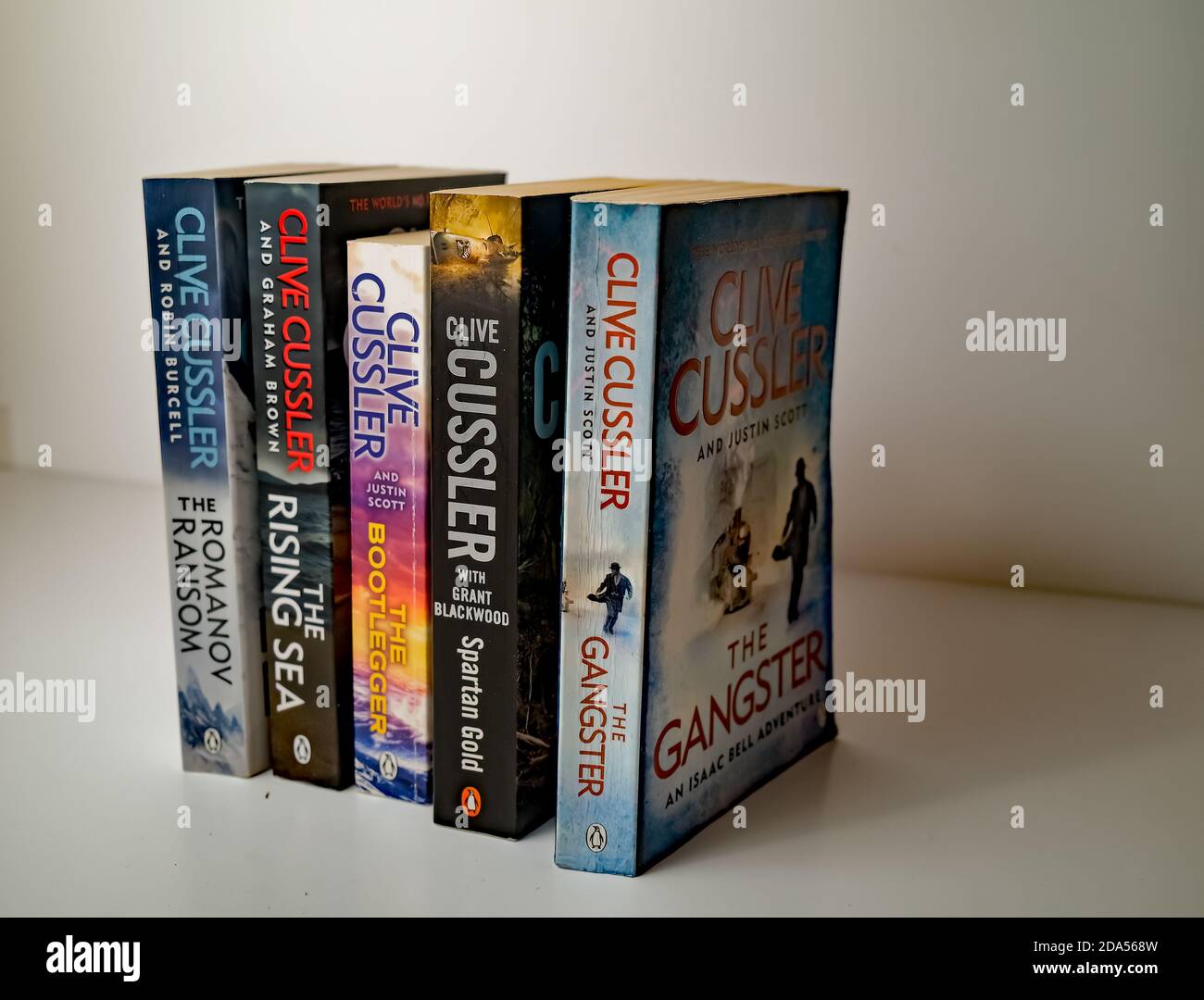 Norwich, Norfolk, Regno Unito – Novembre 08 2020. Foto editoriale illustrativa di una selezione di libri cartacei di genere thriller scritti da Clive Cussler isolat Foto Stock