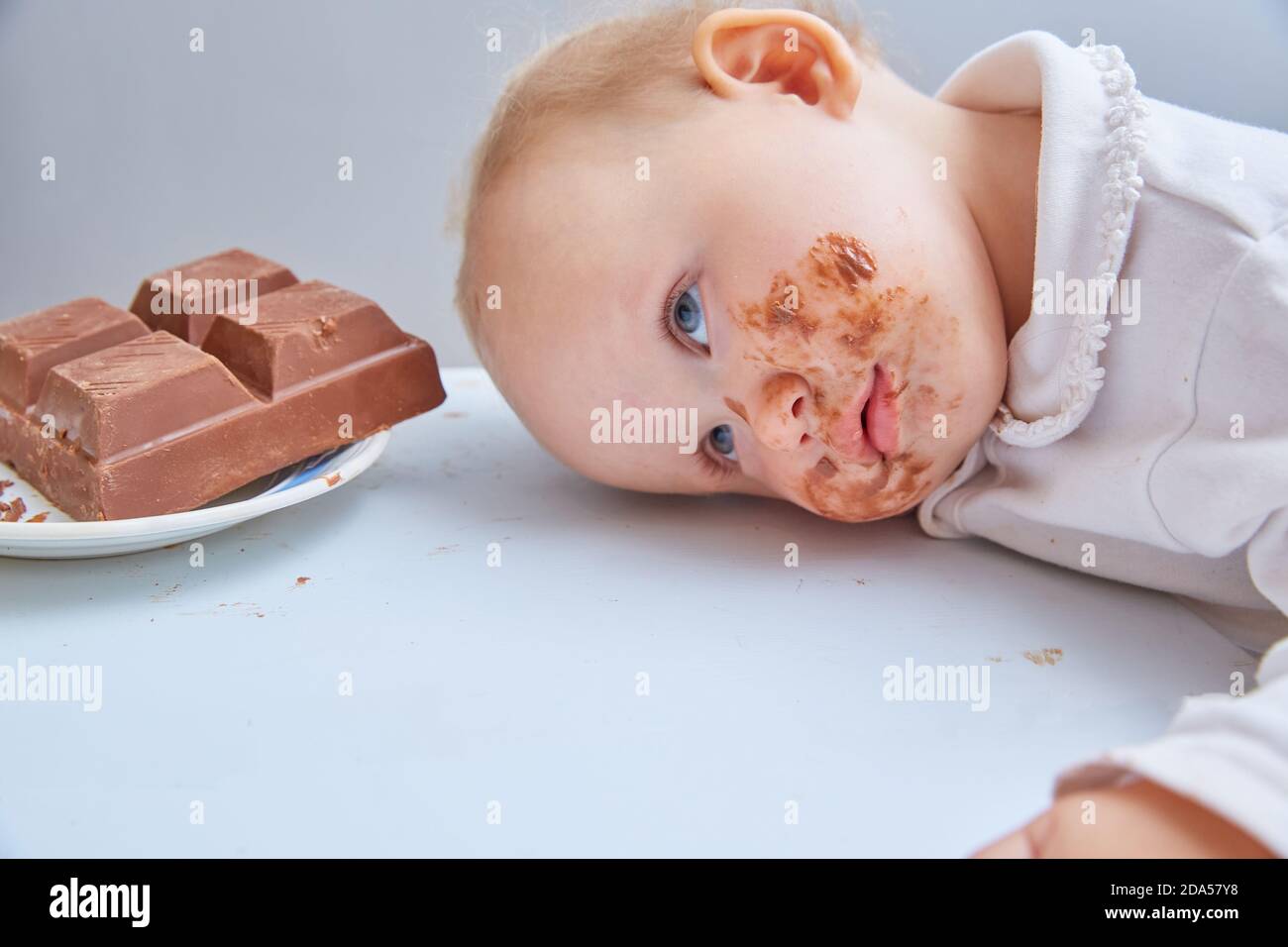 Il bambino è stanco di mangiare il cioccolato. Overeated Foto Stock