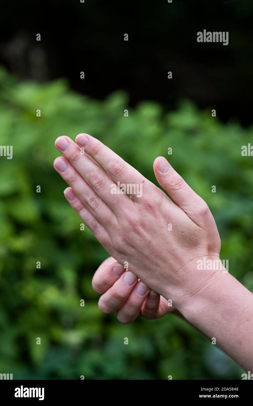 Primo piano delle mani di una donna, punti meridiani prementi sulle mani, terapia Foto Stock