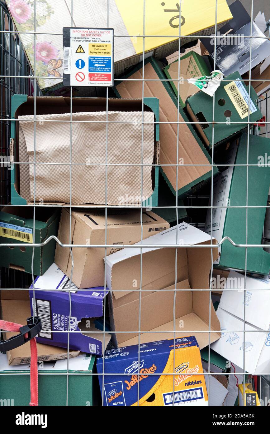 Primo piano di scatole di cartone riciclabili per il riciclaggio dietro il filo nel carrello della gabbia del rullo del supermercato Foto Stock
