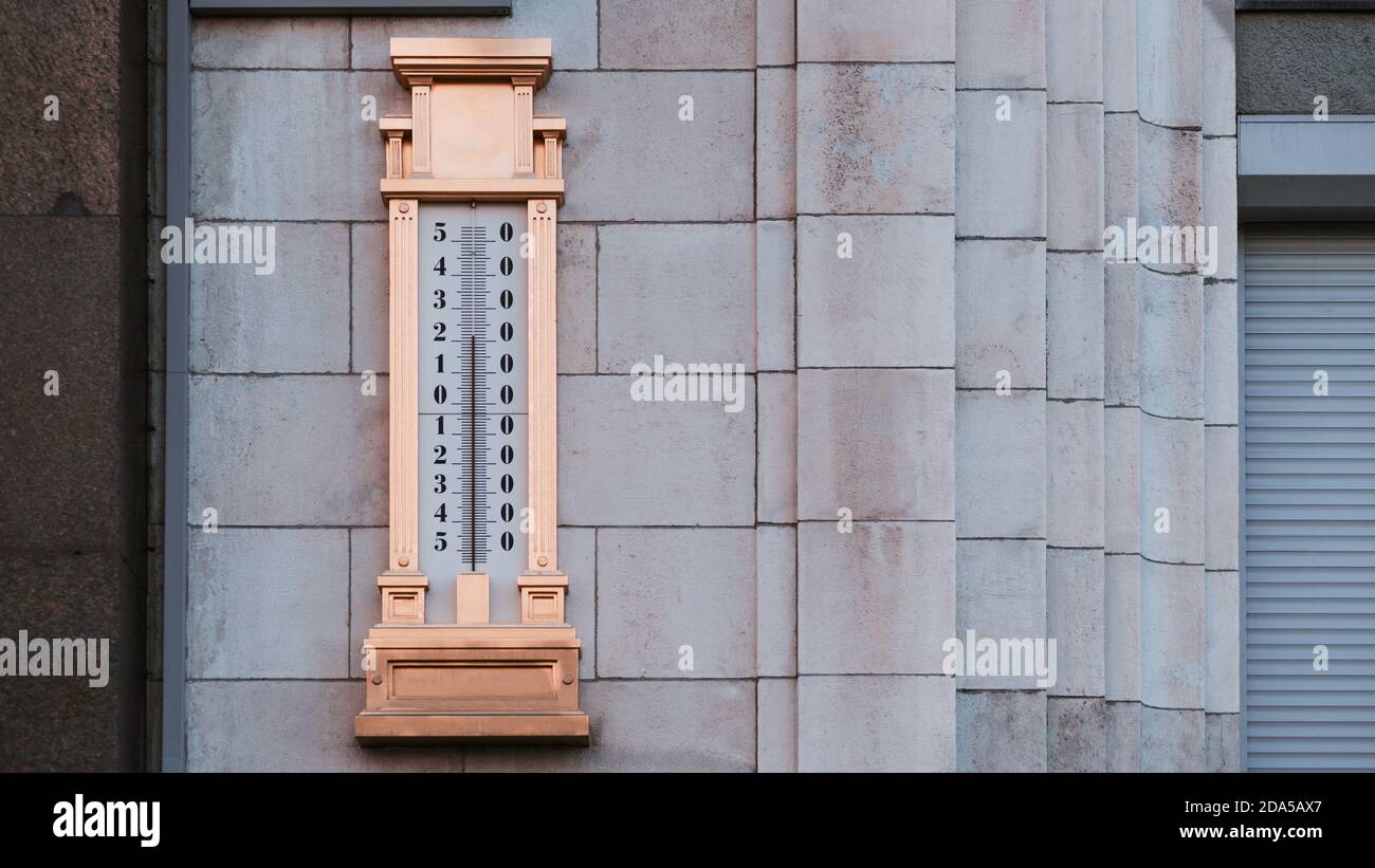 Un gigantesco termometro a mercurio dorato a circa 25 con una scala da meno 54 a più 54 gradi intorno a zero, appeso sulla parete di pietra sulla strada a s. Foto Stock