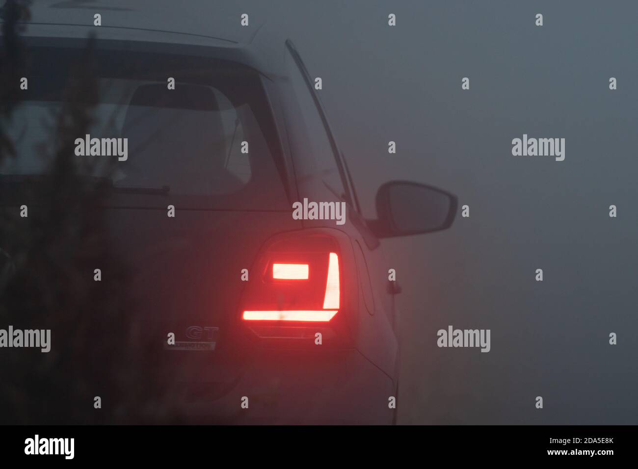 Luci di coda di un'auto in nebbia fitta, ora blu, sera nebbia, notte nebbia, auto Foto Stock