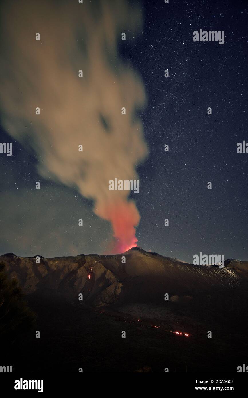 Fumo dal vulcano Etna durante un'eruzione notturna contro il cielo stellato, Sicilia Foto Stock