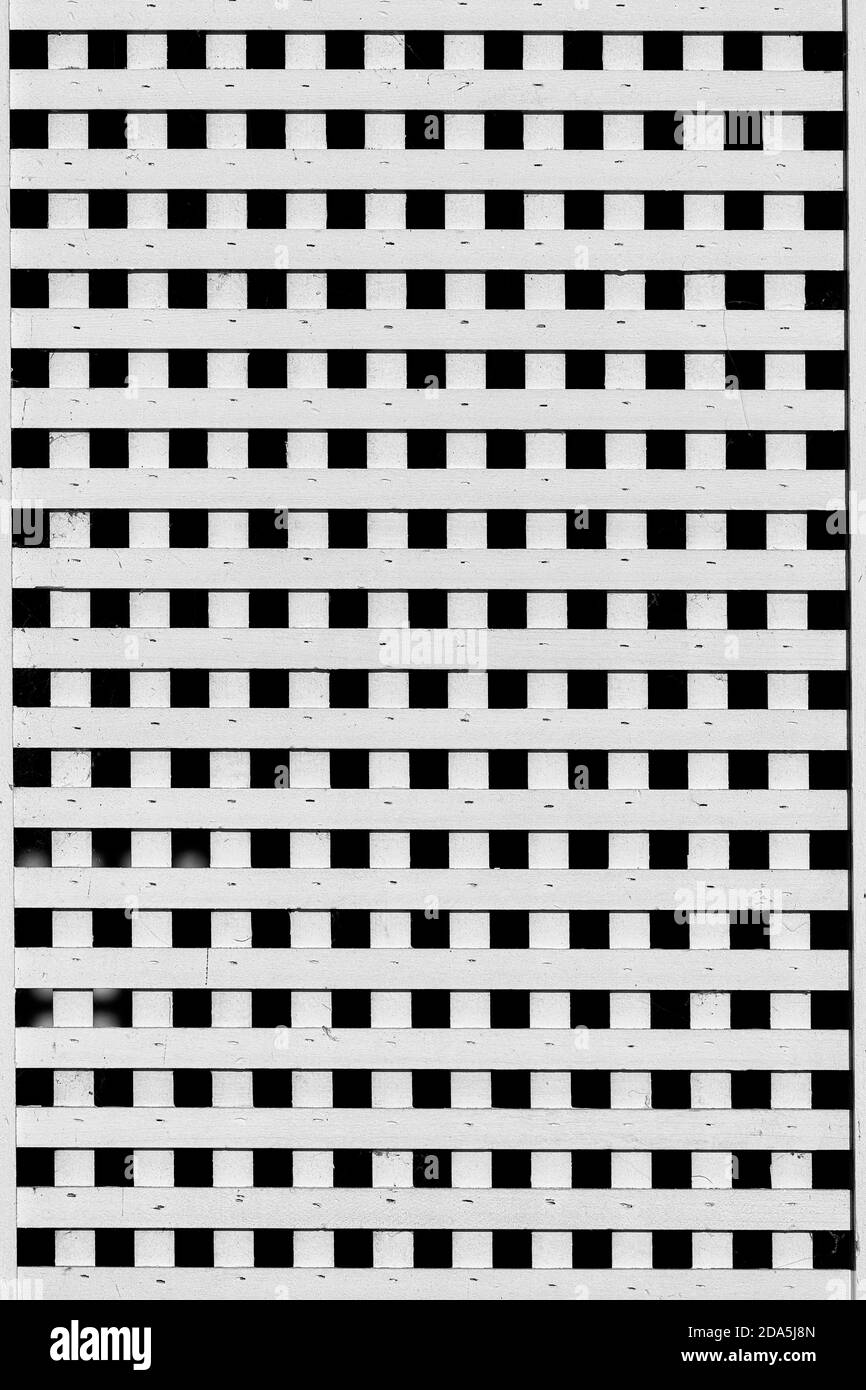Le doghe bianche di legno formano un modello astratto a griglia ripetitiva sulla facciata di vecchio edificio Foto Stock