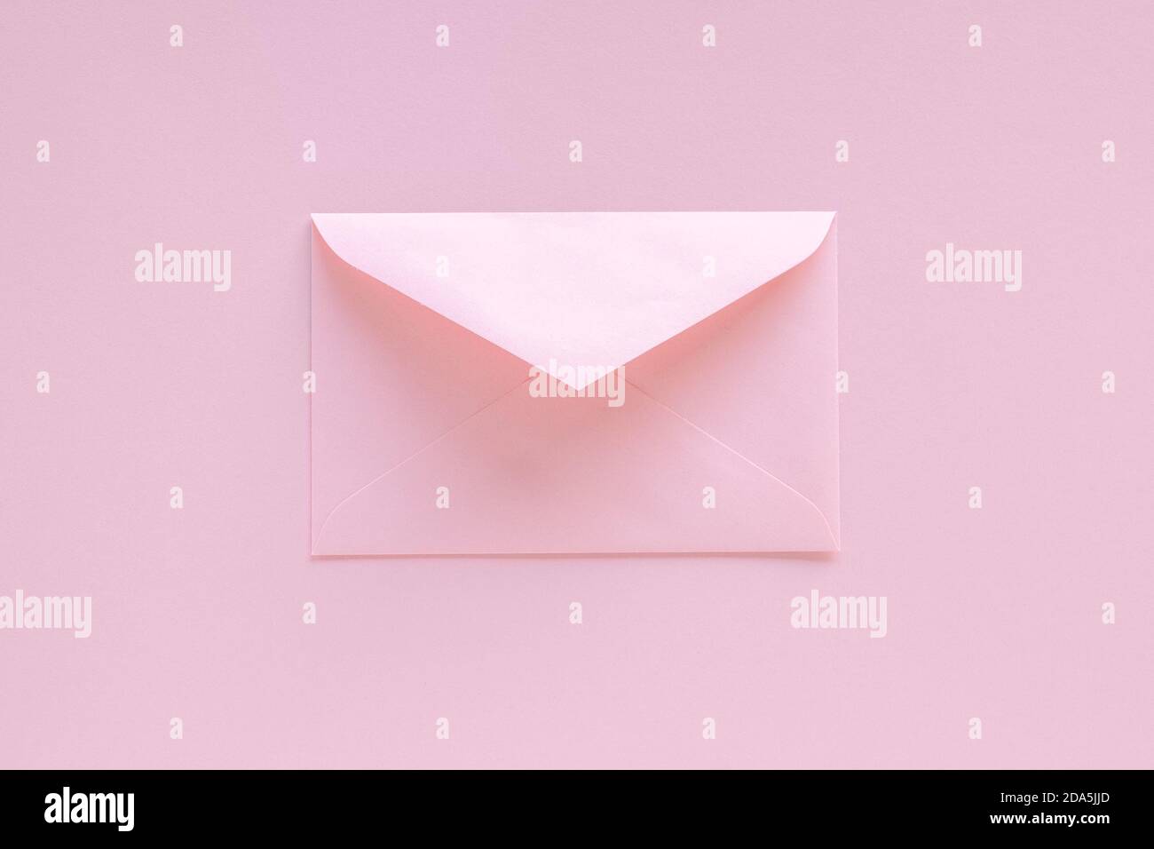 Busta rosa con biglietto d'auguri su sfondo rosa pastello. Lettera con congratulazioni, lettera a Babbo Natale. Natale o Capodanno 2021 minimo Foto Stock