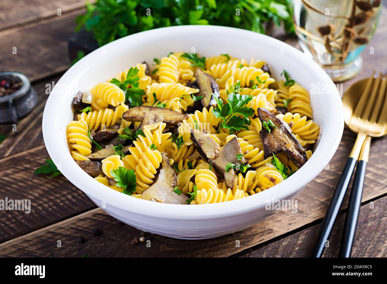 La pasta dei fusilli è priva di glutine con funghi di bosco su un piatto bianco. Cibo vegetariano / vegano. Cucina italiana. Foto Stock