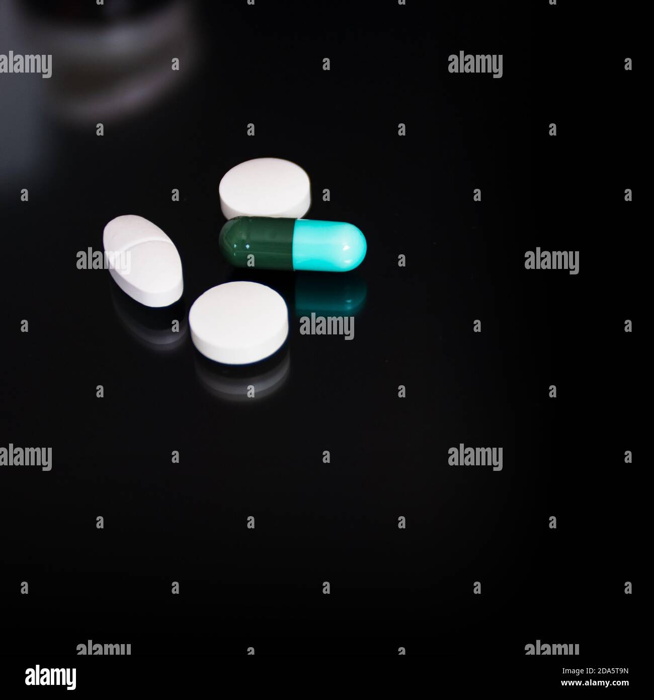 Concetto medico, capsula di farmaco per il trattamento su sfondo nero. Foto Stock