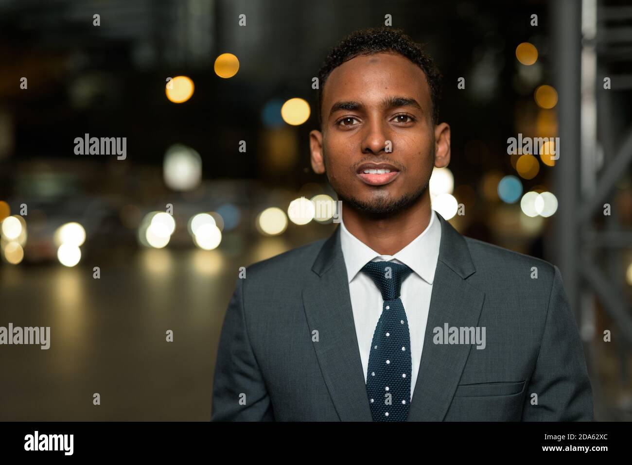 Volto di uomo d'affari africano sorridente di notte in città Foto Stock