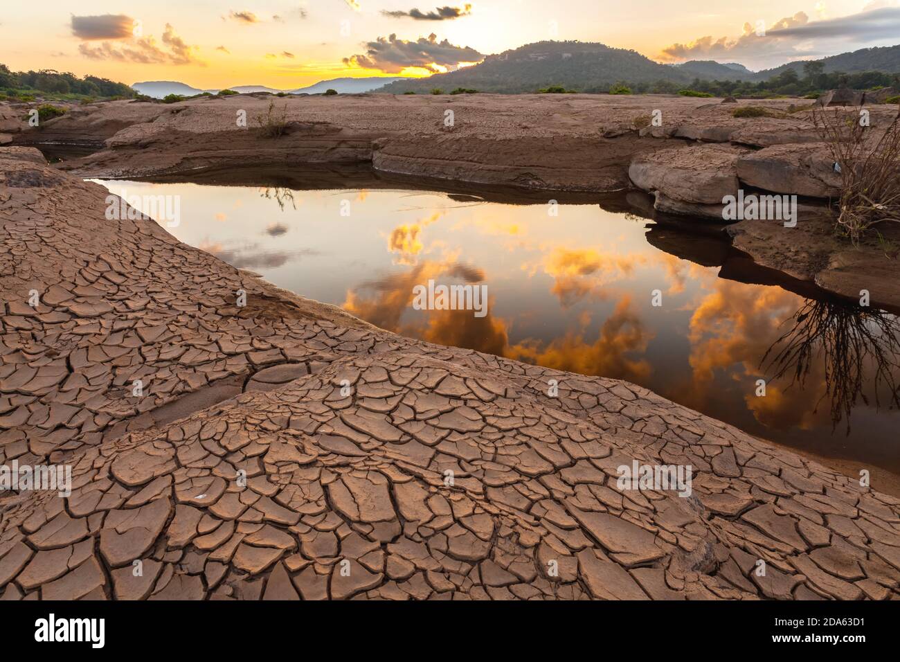 Terra spaccata vicino all'acqua di essiccazione al crepuscolo a Sam Pan Bok nel fiume Mekong. Provincia di Ubonratchathani, Thailandia Foto Stock