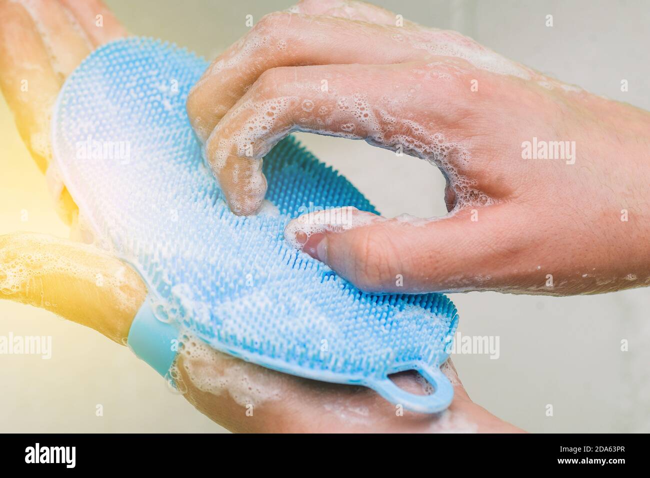 Lavarsi le mani con sapone. Una donna le pulisce le mani dai virus con un pennello blu. Prevenzione del coronavirus, igiene. Protezione da infezioni Foto Stock