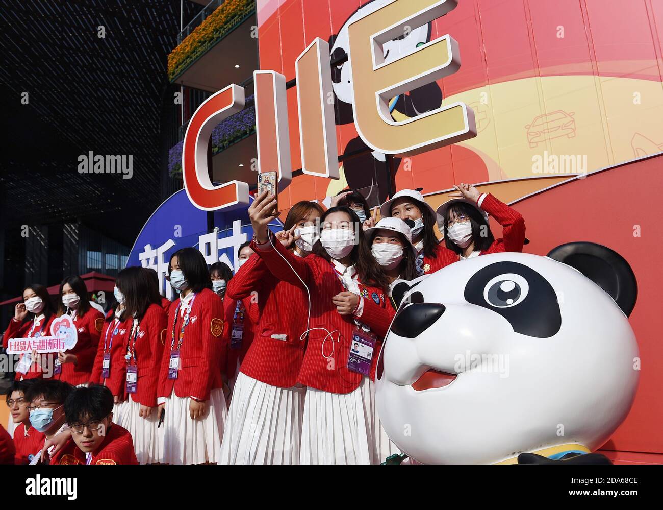 Shanghai, Cina. 10 Nov 2020. I volontari posano per una foto di gruppo davanti alle decorazioni durante il terzo China International Import Expo (CIIE) a Shanghai, Cina orientale, 10 novembre 2020. La fiera è prevista per il 10 novembre. I membri dello staff, gli espositori e i visitatori scattano foto per conservare momenti preziosi dell'evento. Credit: Zhao Dingzhe/Xinhua/Alamy Live News Foto Stock
