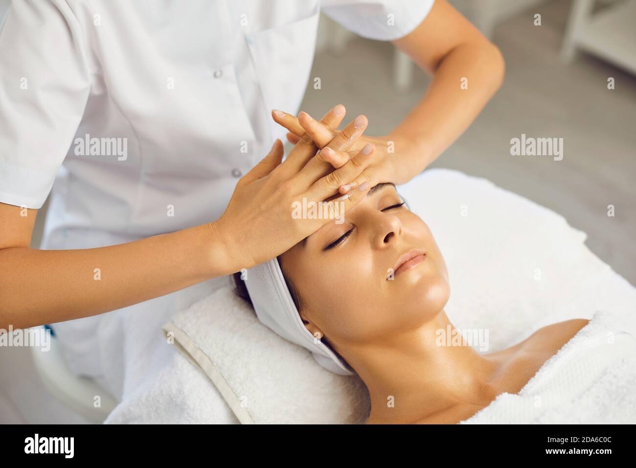 Massaggio viso. L'estetista effettua un massaggio viso anti-invecchiamento con le mani in una clinica di cosmetologia Foto Stock