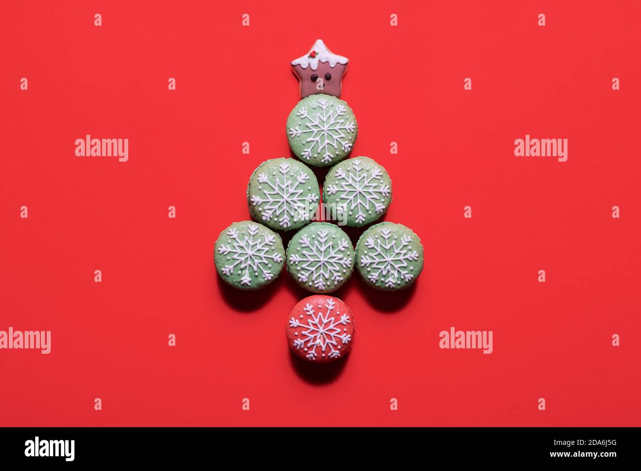 Albero di Natale fatto di macaron decorati macaroni su un rosso sfondo con spazio di copia Foto Stock