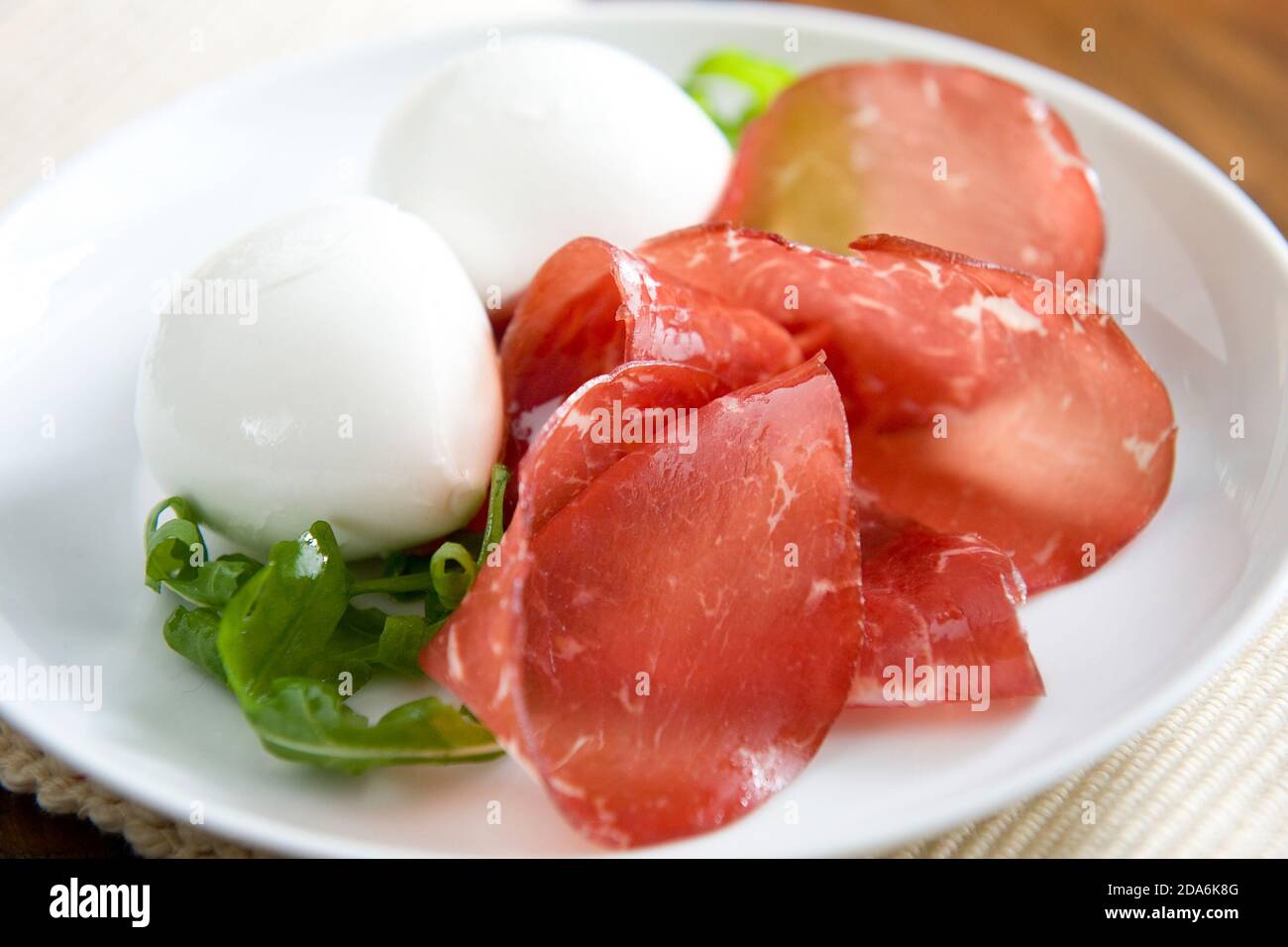 Piatto di mozzarella di bufala della Campania, bresaola della Valtellina e razzo. Il piatto ha i colori della bandiera italiana Foto Stock