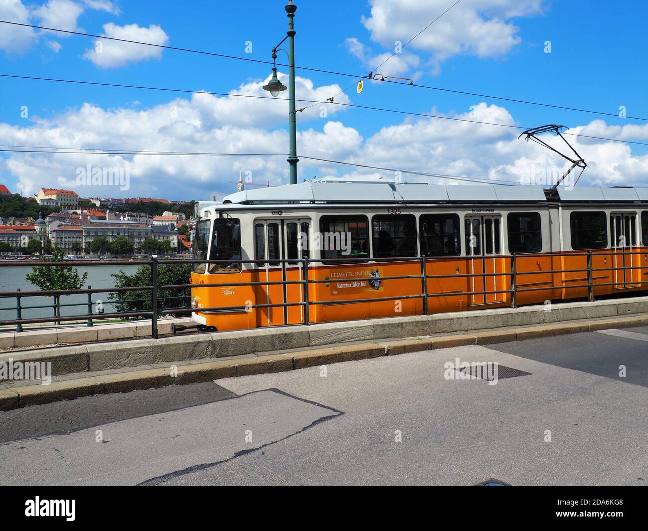 BUDAPEST, UNGHERIA - 23 luglio 2020: Budapest, Ungheria - 23 luglio 2020: Tram elettrico giallo che va sulla riva del Danubio in estate a Budapest, Ungheria Foto Stock