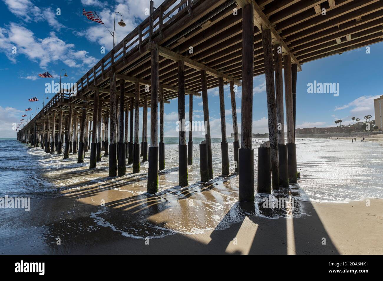 Storico molo in legno sulla spiaggia di Ventura, nel sud della California, con cielo nuvoloso. Foto Stock