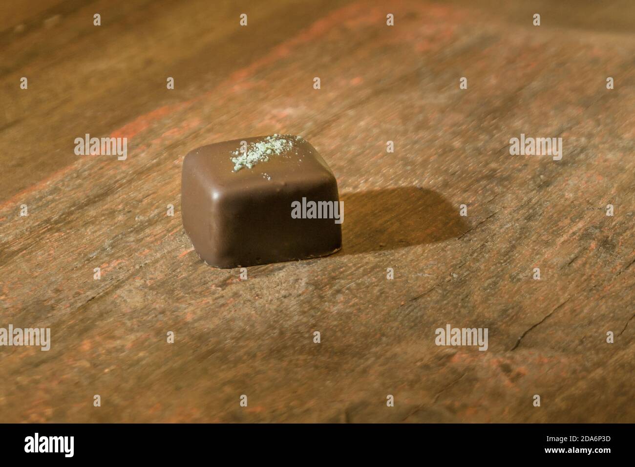 Pralina di menta al cioccolato fondente su un tavolo di legno marrone Foto Stock