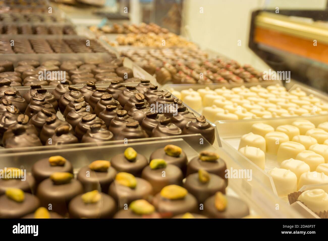 Patern di molte praline di cioccolato diverse in vetrina presso il negozio Foto Stock