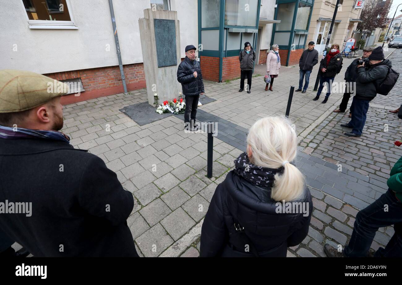 Rostock, Germania. 10 Nov 2020. Durante una breve cerimonia commemorativa in occasione della notte del pogrom del Reich, Yuri Rosov, presidente della Comunità ebraica di Rostock, parla alla stele sulla ex sede della sinagoga, di fronte a Yuriy Kadnykov (l-r), Rabbi di Stato, e Regine Lück, presidente del Parlamento di Rostock. Durante i pogrom di novembre, la notte dal 9 al 10 novembre 1938, i socialisti nazionali hanno messo a fuoco sinagoghe, negozi e appartamenti ebraici in tutta la Germania e hanno maltrattato, rapito e assassinato cittadini ebrei. Credit: Bernd Wüstneck/dpa-Zentralbild/d/dpa/Alamy Live News Foto Stock