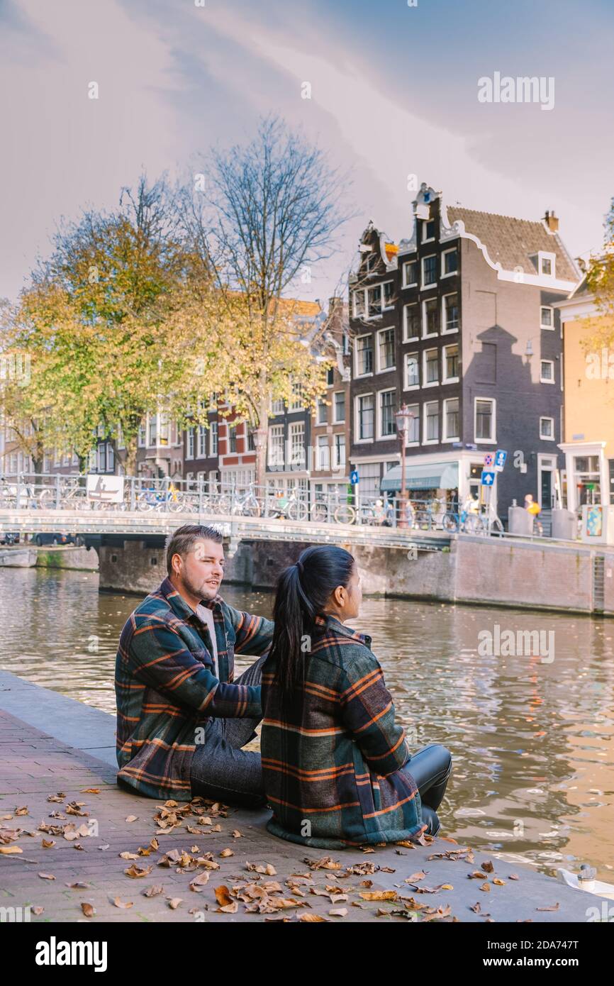 Amsterdam Olanda durante l'autunno, uomini e donne in coppia visitano la  cituia di Amsterdam con colori arancioni lungo il canale nel mese di ottobre  Foto stock - Alamy